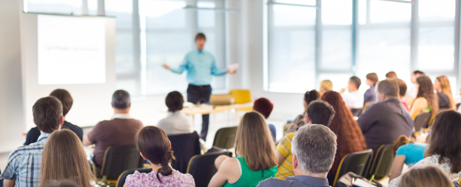 a group of people sitting in chairs watching a presenter